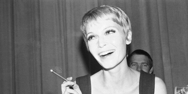 Cigar-smoking Mia Farrow, wife of American singer Frank Sinatra, is shown in her hotel room in Berlin, during a news conference, April 20, 1967. She will star in the movie