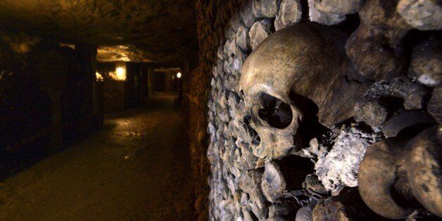 Photo taken on August 7, 2014 at the Catacombs of Paris shows skulls and bones stacked and arranged. These underground quarries were used to store the remains of generations of Parisians in a bid to cope with the overcrowding of Paris' cemeteries at the end of the 18th century, and are now a popular tourist attraction. AFP PHOTO/DOMINIQUE FAGET (Photo credit should read DOMINIQUE FAGET/AFP/Getty Images)