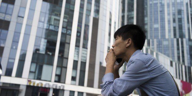 A man smokes a cigarette in Beijing on June 1, 2015. The toughest anti-smoking legislation in China's history came into effect on June 1 in Beijing, with unprecedented fines and a hotline to report offenders but fears of weak enforcement. AFP PHOTO / FRED DUFOUR (Photo credit should read FRED DUFOUR/AFP/Getty Images)