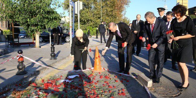 ANKARA, TURKEY - OCTOBER 14: Turkish President Recep Tayyip Erdogan (L-2), his wife Emine Erdogan (L), Finnish President Sauli Niinisto (R-2) and and his wife Jenni Haukio (R) lay red carnations at the site of twin bombings to pay tribute to the victims of the attacks near Ankara train station on October 14, 2015 in Ankara, Turkey. Two suicide bombers, using five kilograms of TNT explosives each, carried out Saturday's twin bomb blasts in Ankara that killed at least 97 people, Turkish Deputy Prime Minister Numan Kurtulmus said late Monday. (Photo by Kayhan Ozer/Anadolu Agency/Getty Images)