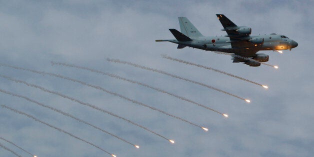 Japan Maritime Self-Defense Force's P-1 patrol plane fires flares during an event held ahead of Sunday's official triennial Maritime Self-Defense Force fleet review off Sagami Bay, south of Tokyo, Thursday, Oct. 15, 2015. A fleet of Japanese navy vessels sailed Sagami Bay on Thursday in a show of display of the navyâs destroyers, submarines and aircraft. (AP Photo/Koji Ueda)