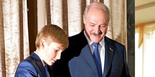 Belarus' President Alexander Lukashenko (R) looks on as his son Nikolay casts his ballot during presidential elections at a polling station in Minsk on October 11, 2015. Belarussians began voting on October 11 in an election that is likely to see authoritarian President Alexander Lukashenko claim a fifth term, with the EU possibly lifting sanctions against him if the polls take place without incident. AFP PHOTO / MAXIM MALINOVSKY (Photo credit should read MAXIM MALINOVSKY/AFP/Getty Images)