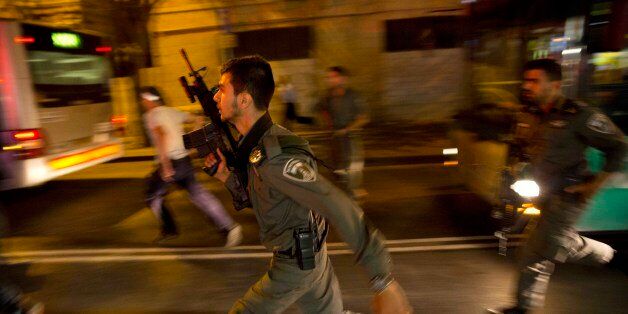 Israeli policemen run looking for a possible stabbing suspect in Jerusalem, Wednesday, Oct. 14, 2015. An Israeli woman was stabbed by an Arab and attacker was shot, the police spokesman said. (AP Photo/Dusan Vranic)