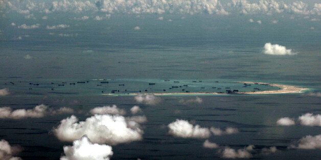 FILE - In this May 11, 2015, file photo, an aerial photo taken through a glass window of a military plane shows China's alleged on-going reclamation of Mischief Reef in the Spratly Islands in the South China Sea. As expectations grow that the U.S. Navy will directly challenge Beijingâs South China Sea claims, China is engaging in some serious image-building for its own military by hosting two international security forums beginning Friday, Oct. 16, 2015. (Ritchie B. Tongo/Pool Photo via AP,