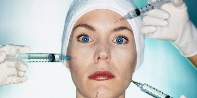 Mixed race woman having facial injections