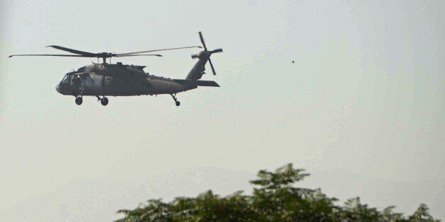 A US helicopter flies over Afghanistan's Jalalabad Airport, where a US C-130 military transport plane crashed in Jalalabad on October 2, 2015. The Taliban claimed October 1 to have shot down a US military transport plane in eastern Afghanistan in a crash that killed 11 people, as the battle for Kunduz raged after the emboldened militants briefly seized the city.The Taliban's stunning success in Kunduz, their biggest tactical success since 2001, marks a blow for Afghanistan's NATO-trained forces, who have largely been fighting on their own since December 2014. NATO has not yet confirmed the cause of Friday's crash. The Taliban regularly claim to have shot down military aircraft.Our mujahideen have shot down a four-engine US aircraft in Jalalabad,' Taliban spokesman Zabihullah Mujahid said on Twitter.'Based on credible information 15 invading forces and a number of puppet troops were killed.' AFP PHOTO / Noorullah Shirzada (Photo credit should read Noorullah Shirzada/AFP/Getty Images)