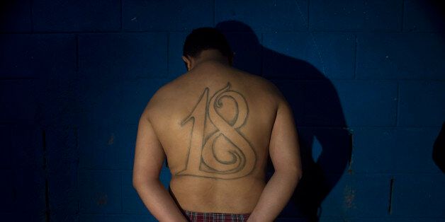 Cesar Vladimir Montoya Climaco stands in front of a wall, handcuffed, after his arrest in San Salvador, El Salvador, late Tuesday July 28, 2015. Authorities in El Salvador have arrested Montoya, a leader of the Barrio 18 gang, believed responsible for a string of threats and attacks on bus drivers that has disrupted public transportation in the capital. (AP Photo/Salvador Melendez)