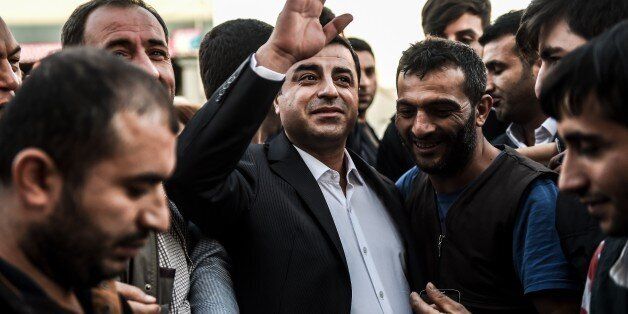 Selahattin Demirtas (C), leader of pro-Kurdish Peoples' Democracy Party (HDP), waves to workers during a visit to the fruit and vegatable market as part of the election campaign on October 9, 2015 in Istanbul. Turkey holds snap elections on November 1, after coalition talks failed. AFP PHOTO/OZAN KOSE (Photo credit should read OZAN KOSE/AFP/Getty Images)