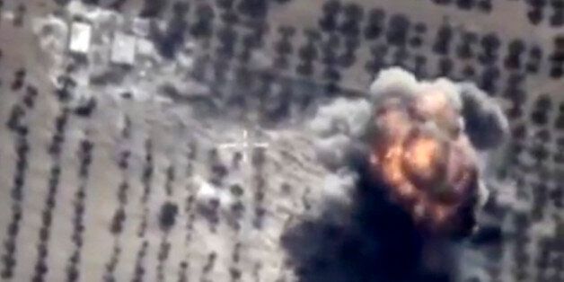 In this photo made from the footage taken from Russian Defense Ministry official web site on Friday, Oct. 16, 2015 showing a target hit during s Russian air raid in Syria. Russian Defense Ministry said the strike was performed by an Su-24M bomber in Idlib province. (AP Photo/ Russian Defense Ministry Press Service)