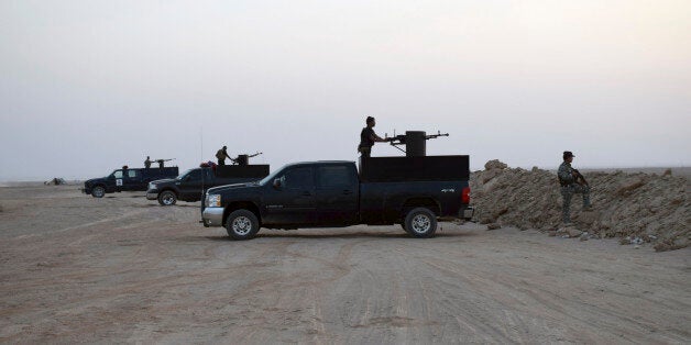 In this Thursday, Oct. 15, 2015 photo, Iraqi security forces and Sunni volunteer tribal fighters stand guard as the sun sets after clashes against Islamic State group, Iraqi security forces advanced their position in the eastern suburbs of Ramadi, the capital of Iraq's Anbar province, 70 miles (115 kilometers) west of Baghdad, Iraq. (AP Photo)