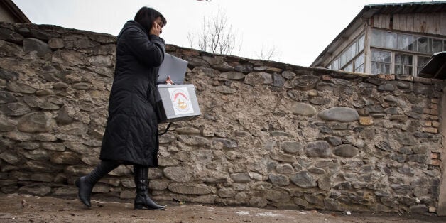 Member of electoral committee walk along a street in Tskhinvali in Georgia's breakaway province of South Ossetia , Sunday, March 25, 2012. Georgia's breakaway province of South Ossetia is again trying to elect a president after a disputed November election ended in scandal. Four candidates are running in Sunday's election, and none is considered the clear favorite. Neither the winner of the November election, Alla Dzhioyeva, nor her Kremlin-backed rival were allowed to run. (AP Photo/Ignat Kozlov)