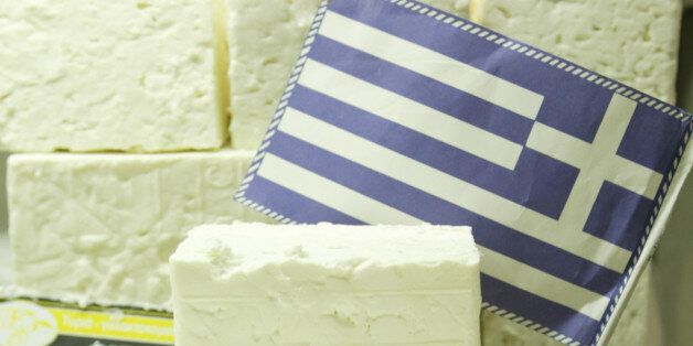 The Greek flag is seen amid traditional feta cheese at a supermarket in central Athens on Tuesday, Oct. 25, 2005. The European Union's highest court on Tuesday backed Greece's long-running bid to claim exclusive rights to the name of the salty cheese. The ruling was a blow to Danish and German producers who also make feta cheese. (AP Photo/Petros Giannakouris)
