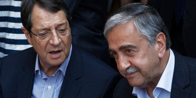 Cyprus President Nicos Anastasiades, left, and Turkish Cypriot leader Mustafa Akinci, speak as they sit at a coffee shop at the Turkish Cypriot breakaway northern part of the Cypriot divided capital Nicosia on Saturday, May 23, 2015. Cyprusâ rival Greek and Turkish Cypriot leaders took a stroll together on both sides of the divided capitalâs medieval center to raise the feel-good factor as talks aimed at reunifying the ethnically split island kick into gear. Itâs the first time that the leaders have done so together since the east Mediterranean island was split in 1974 when Turkey invaded after coup by supporters of union with Greece. (AP Photo/Petros Karadjias)