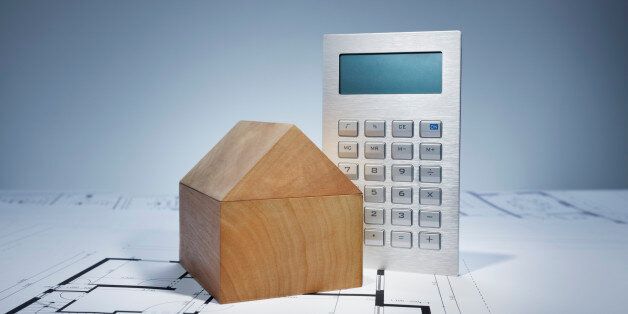 Blueprint with wooden house and calculator