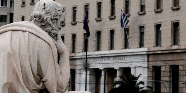 A statue of the ancient Greek philosopher Socrates is pictured with the headquarter of the central Bank of Greece in the background in Athens on Tuesday May 29, 2012. The four biggest Greek banks received 18 billion euros (22.6 billion USD) in rescue funds on May 28, 2012 to help reinforce their capital bases, a Hellenic financial stability fund source said. National Bank, the biggest Greek lender, has received 7.43 billion euros, Piraeus bank 4.7 billion, Eurobank 3.97 billion and Alpha 1.9 billion, the official said.(AP Photo/Dimitri Messinis)
