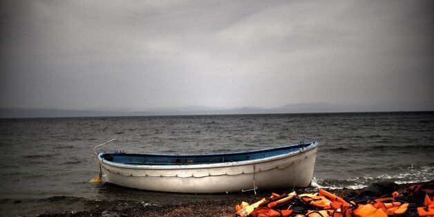 Life jackets and a boat that were used by refugees and migrants to cross the Aegean sea from Turkey lie abandoned on a beach on the Greek Island of Lesbos on October 8, 2015. Europe is grappling with its biggest migration challenge since World War II, with the main surge coming from civil war-torn Syria. AFP PHOTO / ARIS MESSINIS (Photo credit should read ARIS MESSINIS/AFP/Getty Images)