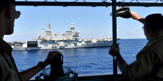 The commander (R) Stefan Klatt of German navy frigate ship Werra salutes the Italian navy carrier Cavour as it sails in the Mediterranean Sea, not far from Libyan territorial waters, on September 23, 2015. The German ship is part of the EU operation EuNavFor Med, rescuing migrants crossing the Mediterranean Sea from North Africa to Europe. AFP PHOTO / ALBERTO PIZZOLI (Photo credit should read ALBERTO PIZZOLI/AFP/Getty Images)