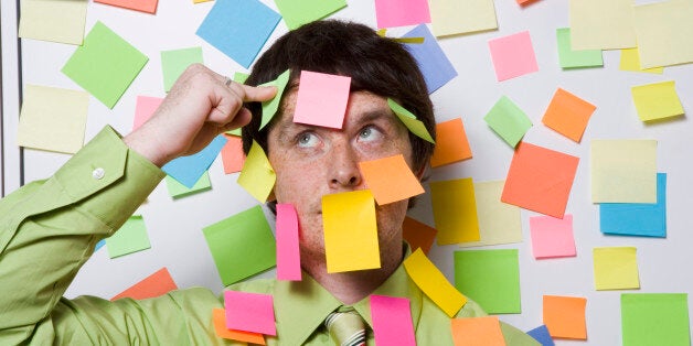 Male office worker covered with sticky notes