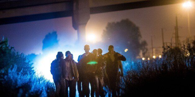 Migrants walk towards the Channel Tunnel site in Frethun, northern France, on August 5, 2015. The European...