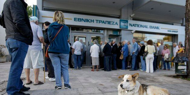 Pensioners stand in a queue as others, left, use the ATMs of a bank in Athens, Wednesday, July 1, 2015. About 1,000 bank branches around the country were ordered by the government to reopen Wednesday to help desperate pensioners without ATM cards cash up to 120 euros ($134) from their retirement checks. Eurozone finance ministers were set to weigh Greece's latest proposal for aid Wednesday. (AP Photo/Thanassis Stavrakis)