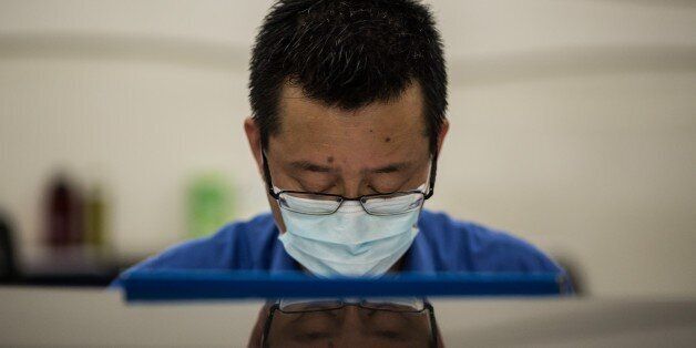 A member of staff wears a face mask at Kowloon station in Hong Kong on June 27, 2015, after a 17-year-old Korean man with a fever sought medical care at a clinic in the station and has since been isolated in hospital where he is being tested for MERS, according to the city's health minister. The city has not reported any cases of MERS, though multiple people have been tested for the virus. AFP PHOTO / ANTHONY WALLACE (Photo credit should read ANTHONY WALLACE/AFP/Getty Images)