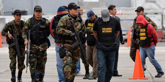 Mexican detainees Ruben Larios Dug (front) and Josef GutiÃ©rrez Leon (2nd), members of the Sinaloa cartel, arrive to a police air terminal in Lima on September 4, 2014, from the northern city of Trujillo, where they were arrested with possession of 7.6 tons of cocaine seized last week together with seven Peruvian nationals. The seizure --the largest archived in Peru-- was hidden within charcoal conglomerate, waiting to be exported to Spain and Belgium with a calculated street value of 300 million US Dollars. AFP PHOTO/CRIS BOURONCLE (Photo credit should read CRIS BOURONCLE/AFP/Getty Images)