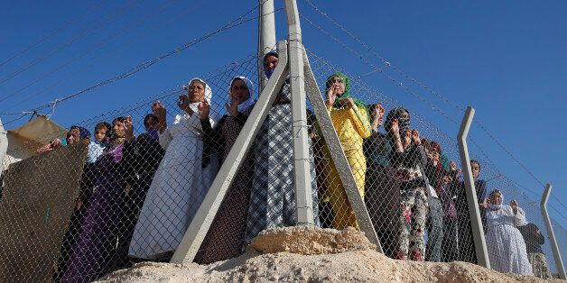 Syrian refugees wait to see the arrival of U.N. High Commissioner for Refugees Antonio Guterres for his visit to the Midyat refugee camp in Mardin, southeastern Turkey, near the Syrian border, Saturday, June 20, 2015. Gutierrez visited the camp which is sheltering those who have fled the 4-year conflict in neighbouring Syria, on the World Refugee Day. The UN refugee agency has said the number of Syrian refugees seeking its help now tops two-million - and could be far higher. Turkey is the world's biggest refugee host with 1.59 million refugees, according to the most recent U.N. figures. (AP Photo/Emrah Gurel)