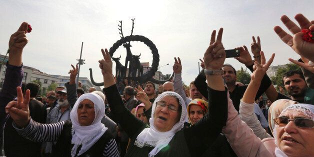 Protesters flash the V-sign as they protest Saturday's bombing attacks, during a rally in Ankara, Turkey, Sunday, Oct. 11, 2015. Turkey declared three days of mourning following Saturday's nearly simultaneous explosions that targeted a peace rally in Ankara to call for increased democracy and an end to the renewed fighting between the Turkish security forces and Kurdish rebels. (AP Photo/Burhan Ozbilici)