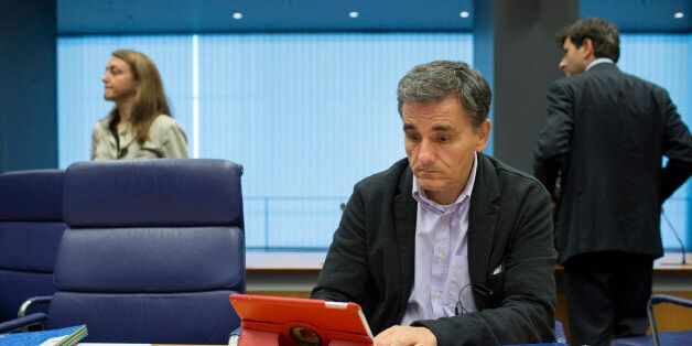 Euclid Tsakalotos, Greece's finance minister, looks at Apple Inc. iPad tablet device ahead of roundtable talks during a Eurogroup meeting in Luxembourg, on Monday, Oct. 5, 2015. French Finance Minister Michel Sapin said Greece needs to make good on its promises with euro-area lenders as soon as possible so the creditors can move on to discuss easing the country's debt burden. Photographer: Jasper Juinen/Bloomberg via Getty Images