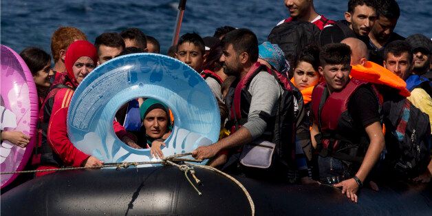 Refugees and migrants arrive on a dinghy after they crossed from Turkey to Lesbos island, Greece, Friday, Sept. 11, 2015. While migrants for years have taken death-defying trips across the Mediterranean to reach the relative peace and comfort of the Europe Union, the flow has hit record proportions this year - notably with an influx of Syrians, Afghans and Eritreans fleeing trouble back home.(AP Photo/Petros Giannakouris)