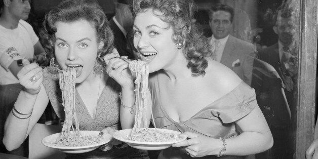Mirv Arvinen (Miss Finland 1955) and Soho's Fair Queen Andria Loran (right) try their hand at scoffing a plate of pasta at the Soho Fair spaghetti-eating contest on Frith Street, Soho, London.
