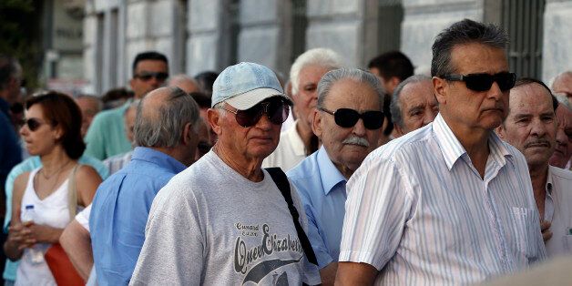 The first customers, most of them pensioners, stand in a queue to enter a branch at National Bank of Greece headquarters in Athens, Monday, July 20, 2015. Greek banks reopen on Monday morning, but many restrictions on transactions, including cash withdrawals, will remain. Also, many goods and services will become more expensive as a result of a rise in Value Added Tax approved by Parliament last Thursday, among the first batch of austerity measures demanded by Greece's creditors. (AP Photo/Thanassis Stavrakis)