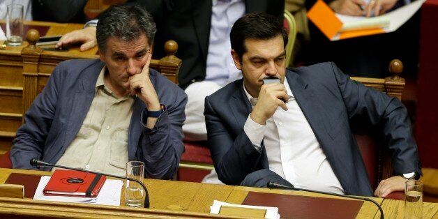 Greece's Prime Minister Alexis Tsipras, right, and Finance Minister Euclid Tsakalotos attend a parliament meeting in Athens, Thursday, July 16, 2015. Greece's Parliament has approved an austerity bill demanded by bailout creditors, despite a significant level of dissent from the governing leftist Syriza party. The bill to impose sweeping tax hikes and spending cuts was approved with the support of three pro-European opposition parties. (AP Photo/Thanassis Stavrakis)