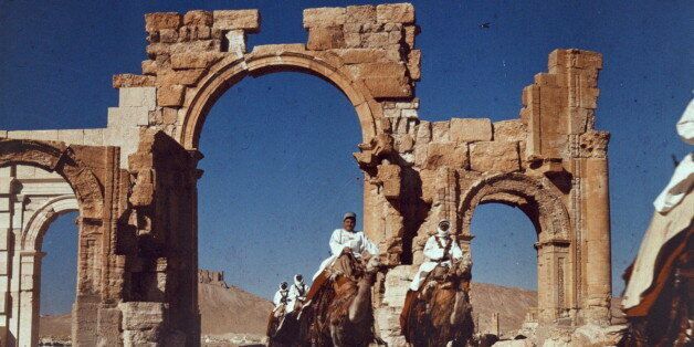 Bedouin men on camels, in front of the Arch of Triumph, Palmyra, Syria 1938. (Photo by: Universal History Archive/UIG via Getty Images)