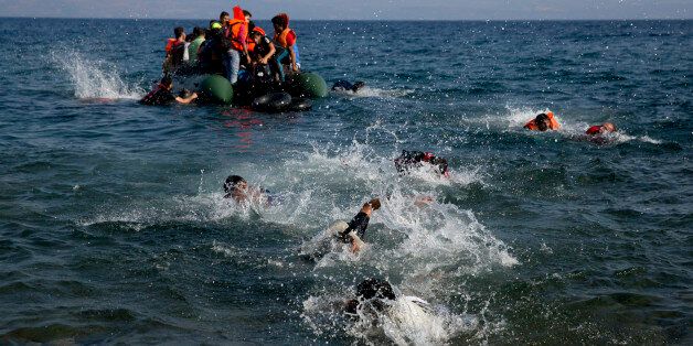 Migrant whose boat stalled at sea while crossing from Turkey to Greece swim to approach the shore of the island of Lesbos, Greece, on Sunday, Sept. 20, 2015. A boat with 46 migrants or refugees has sunk Sunday in Greece and the coast guard says it is searching for 26 missing off the eastern Aegean island of Lesbos. (AP Photo/Petros Giannakouris)