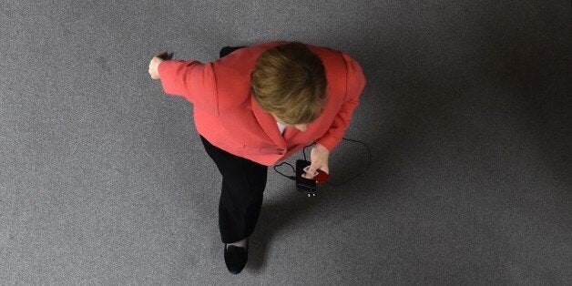 German Chancellor Angela Merkel walks through the plenary hall to vote on a new Greece bail-out deal during a special session at the Bundestag (lower house of parliament) in Berlin on July 17, 2015. Chancellor Angela Merkel made an impassioned plea to German lawmakers to back the new Greece bailout deal that conforms to EU rules and prevents 'chaos' in the crisis-hit country. AFP PHOTO / TOBIAS SCHWARZ (Photo credit should read TOBIAS SCHWARZ/AFP/Getty Images)