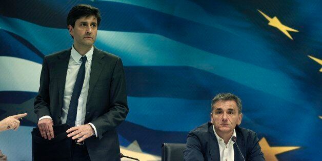 Greek Finance Minister Giorgos Houliarakis, left, arrives as outgoing Finance Minister Euclid Tsakalotos looks on during a handover ceremony in Athens, Friday, Aug. 28, 2015. The new finance minister said his main target would be âto not waste valuable timeâ and strengthen the countryâs banking system as quickly as possible.(AP Photo/Petros Giannakouris)