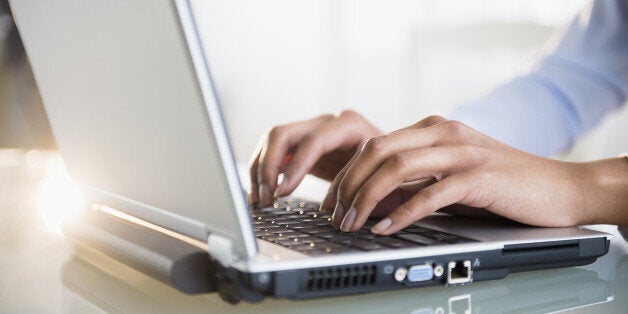 Mixed race businesswoman working on laptop