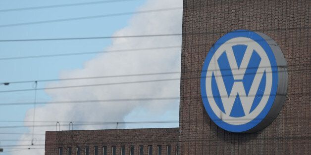 A man looks through binoculars as he stands next to a corporate logo of Volkswagen on the rooftop of the former power plant of the German car manufacturer inÂ Wolfsburg, Germany, Friday, Sept. 25, 2015. Volkswagen's supervisory board is meeting Friday to discuss who to name as CEO after Martin Winterkorn quit the job this week over an emissions-rigging scandal that's rocking the world's top-selling automaker. (Rainer Jensen/dpa via AP)