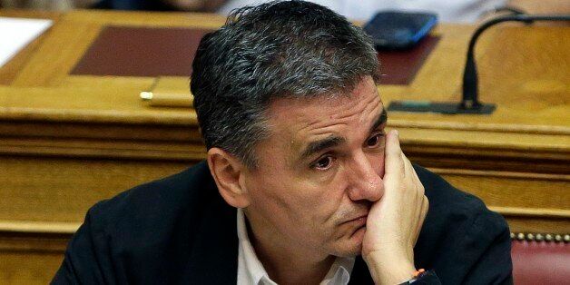 Greek Finance Minister Euclid Tsakalotos attends an emergency parliament session at the Greek Parliament in Athens, Wednesday, July 22, 2015. Greece's liquidity-starved banks got a new cash injection from the European Central Bank on Wednesday, hours before a key vote in parliament on further economic reforms demanded by international creditors in return for a third bailout. (AP Photo/Thanassis Stavrakis)