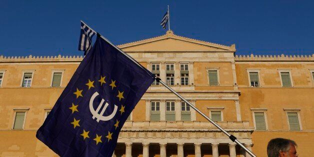 A pro-Euro demonstrator holds a European Union flag in front of Greek Parliament during a rally at Syntagma square in Athens, Thursday, July 9, 2015. Hopes that Greece can get a rescue deal that will prevent a catastrophic exit from the euro rose on Thursday, after key creditors said they were open to discussing how to ease the country's debt load, a long-time sticking point in their talks. (AP Photo/Petros Karadjias)