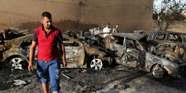 Civilians inspect the site of a car bomb attack on Palestine Street in eastern Baghdad, Iraq, Wednesday, June 24, 2015. (AP Photo/Karim Kadim)