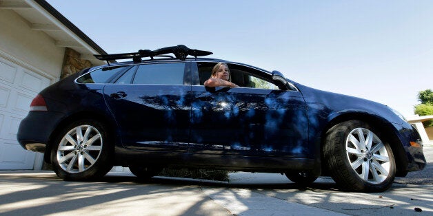 In this Sept. 23, 2015 photo, Zandy Hartig poses for a picture in her 2013 Volkswagen Jetta Sportwagen diesel in Studio City, Calif. Following disclosures that Volkswagen developed software for its 2-liter diesel engine that could better control pollutants during testing than in real-world driving, there thereâs a lot up in the air for owners of Jettas, Golfs, Passats and Beetles and Audiâs A3. (AP Photo/Chris Carlson)