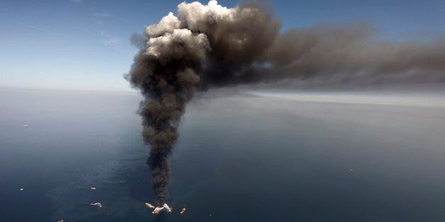 FILE - In this April 2010 file photo, oil can be seen in the Gulf of Mexico, more than 50 miles southeast of Venice on Louisiana's tip, as a large plume of smoke rises from fires on BP's Deepwater Horizon offshore oil rig. Deep-water drilling is set to resume near the site of the catastrophic BP PLC well blowout that killed 11 workers and caused the nation's largest offshore oil spill five years ago off the coast of Louisiana. (AP Photo/Gerald Herbert, File)