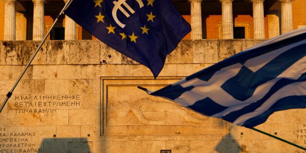 Pro-Euro demonstrators wave a Greek flag, right, and a European Union flag in front of the Tomb of the Unknown Soldier during a rally at Syntagma square in Athens, Thursday, July 9, 2015. Hopes that Greece can get a rescue deal that will prevent a catastrophic exit from the euro rose on Thursday, after key creditors said they were open to discussing how to ease the country's debt load, a long-time sticking point in their talks. (AP Photo/Petros Karadjias)