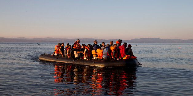 Syrian refugees arrive aboard a dinghy after crossing from Turkey, to the island of Lesbos, Greece. Friday,...