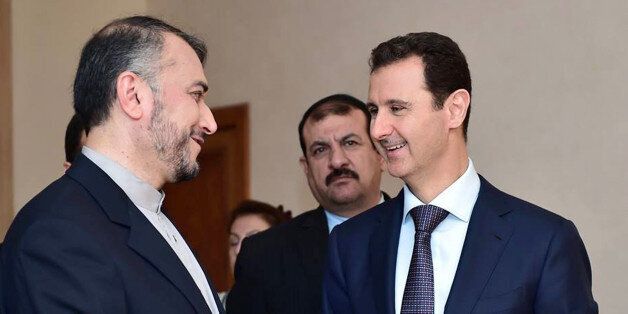 In this photo released on the official Facebook page of the Syrian Presidency, Syrian President Bashar Assad, right, speaks with Iran's Deputy Foreign Minister Hossein Amir Abdollahian, left, in Damascus, Syria, Thursday, Sept. 3, 2015. Abdollahian says Syrian President Bashar Assad has a âpivotal and centralâ role to play in the war on terrorism and is an important part of any solution for the war-torn country. (Syrian Presidency via Facebook)