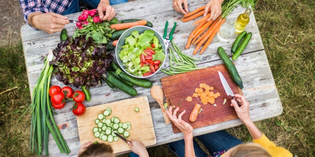 Family preparing fresh salad in a garden