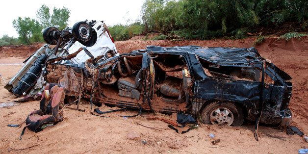 HILDALE, UT - SEPTEMBER 15: The twisted wreckage of two vans that were washed away in a flash flood with women and children inside rest on the bank of Short Creek on September 15, 2015 in Hildale, Utah. Flash Floods from heavy rains on the afternoon of September 14, 2015 washed away two vans in Hildale as they were crossing a flooded creek, killing 12 people with one still missing. (Photo by George Frey/Getty Images)