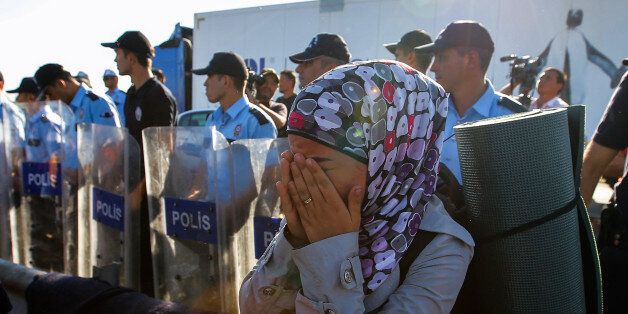 A refugee woman cries at a securit barricade as hundreds of migrants camp for a second day, trying to march down a highway towards Turkeyâs western border with Greece and Bulgaria, near Edirne, Turkey, Saturday, Sept. 19, 2015. The migrants were stopped Friday by Turkish law enforcement on a highway near the city of Edirne, causing a massive traffic jam. (AP Photo/Emrah Gurel)